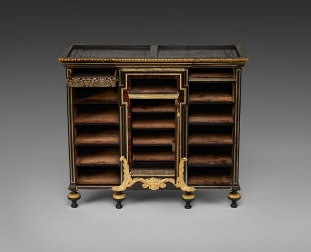 Boulle. Brass and tortoiseshell on the front, plain oak underneath. Always look underneath.