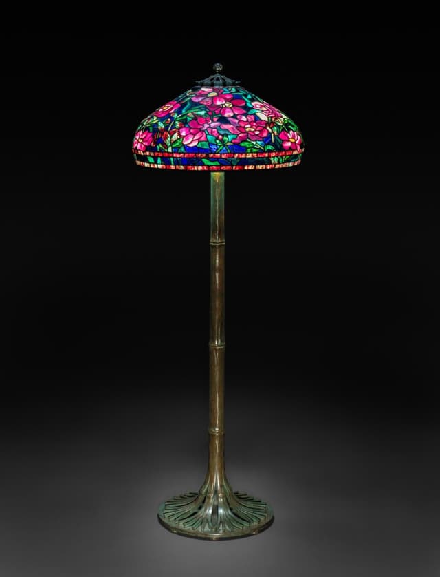 The lamp is a plant: the shade is the flower, the stem carries the wire. Structure and metaphor agree. Rare.